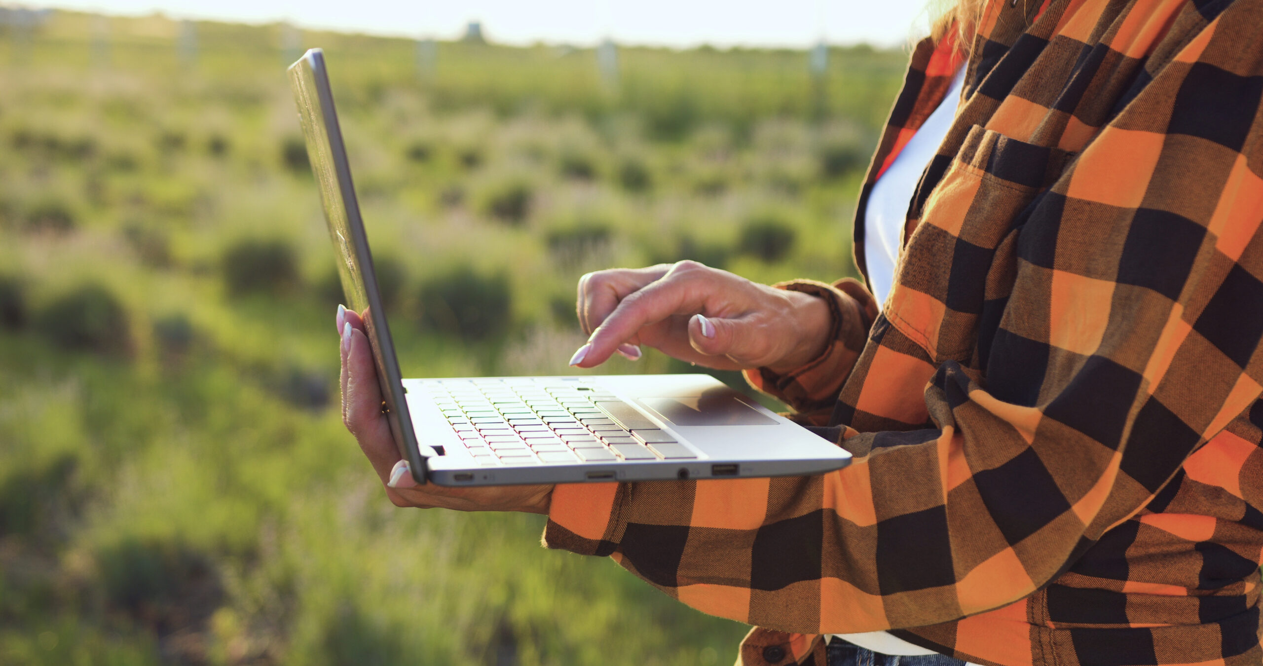 close-up-of-farmers-woman-hands-taking-notes-and-searches-for-information-in-laptop-in-SBI-349820531